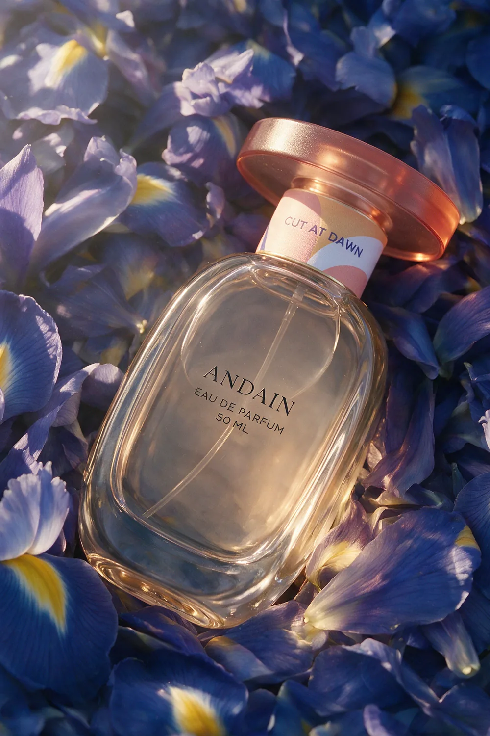 The perfume bottle laid on a dense bed of blue iris petals.
