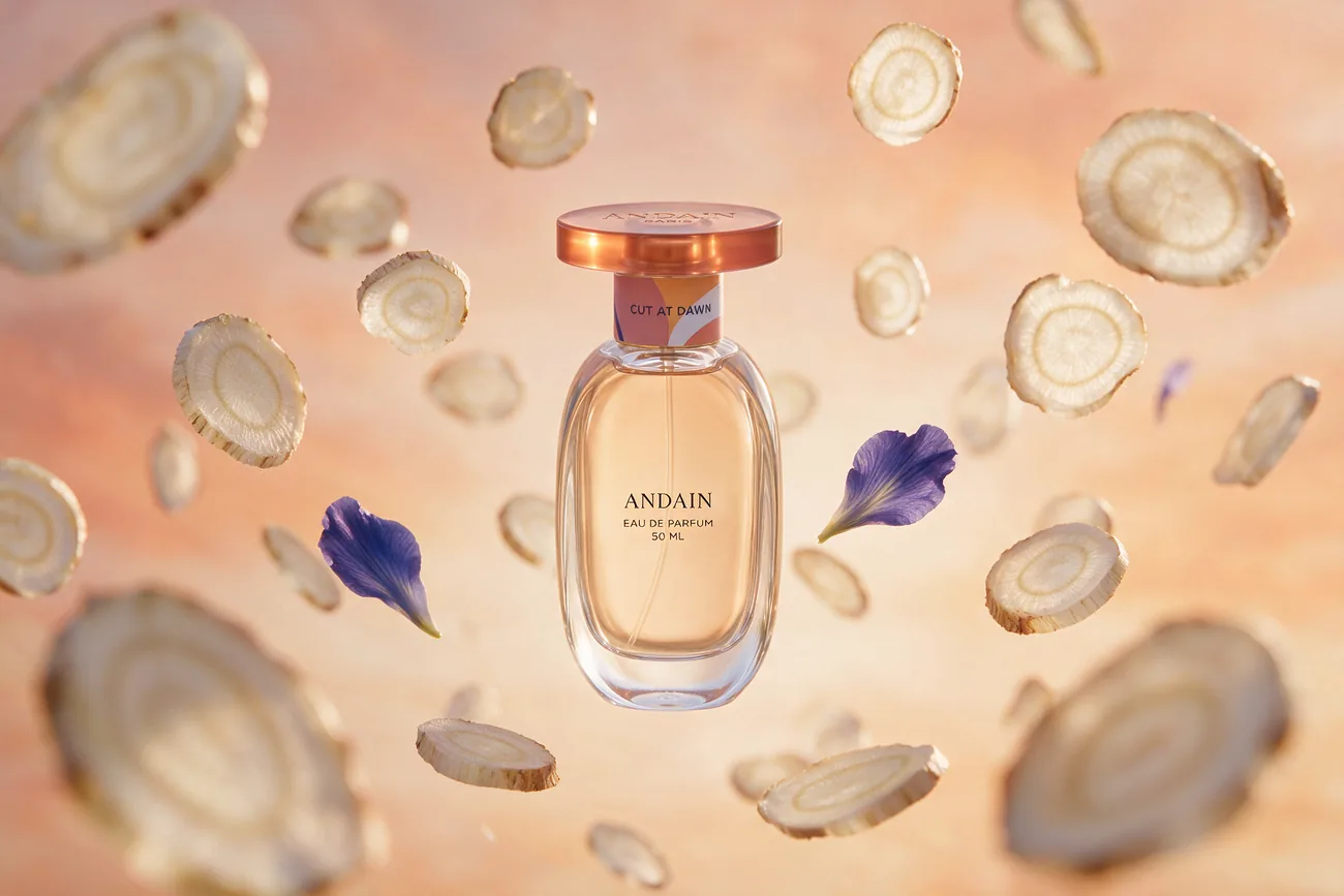 The bottle among suspended slices of orris root and single petals.